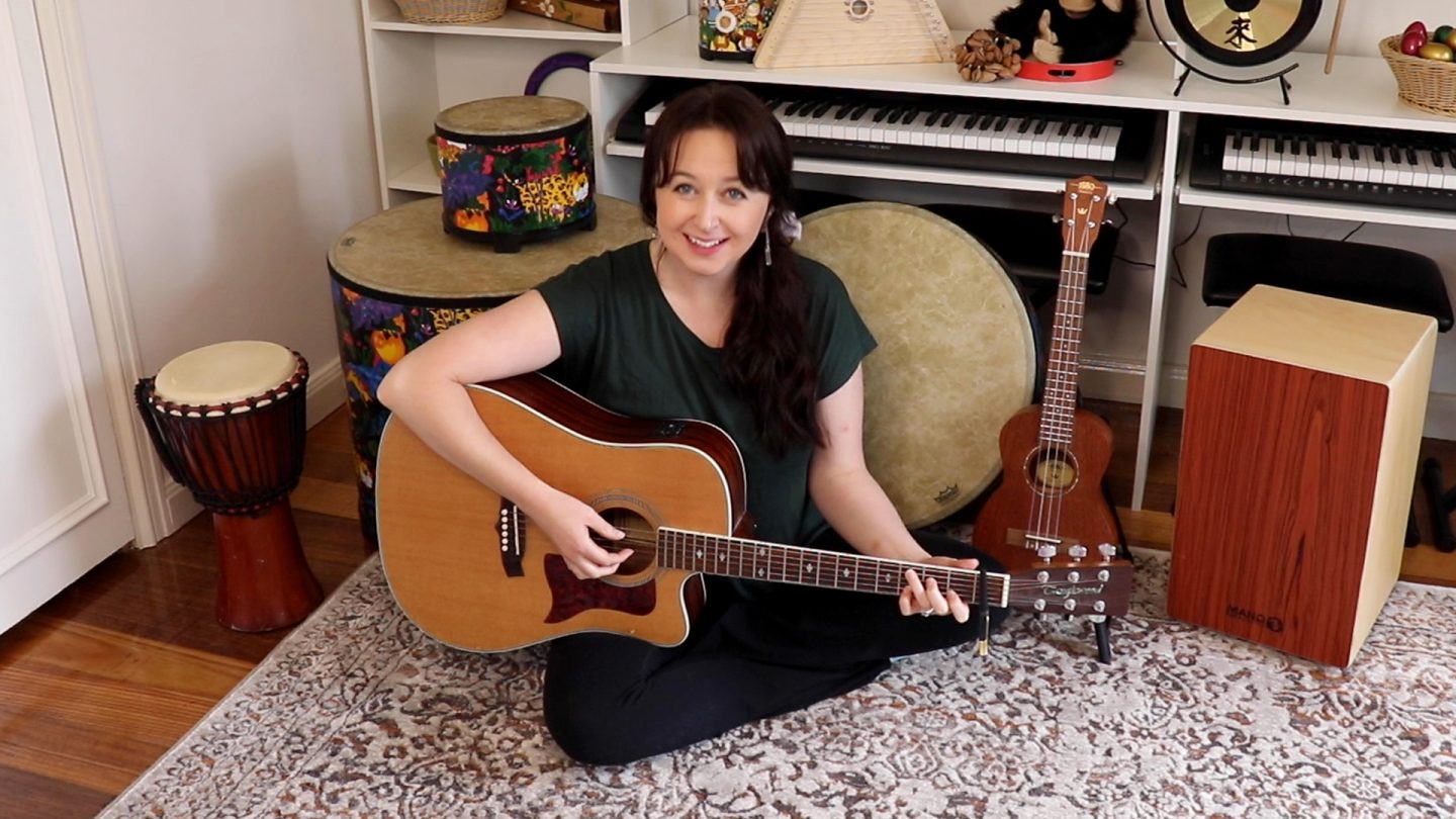 Music teacher holding a guitar