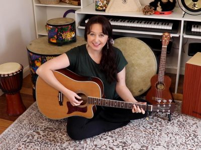 Music teacher holding a guitar